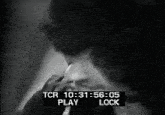 a black and white photo of a man smoking a cigarette with a tcr play and lock screen