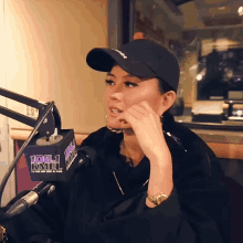 a woman wearing a black hat is talking into a 105.1 kmel microphone