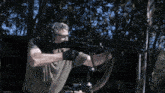 a man wearing headphones and goggles is holding a gun