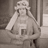 a woman wearing a flowered hat is reading a book titled daily n