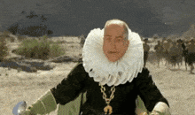 a man in a black and green costume with a gold necklace and a white ruff .