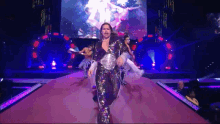 a man in a sequined outfit walks down a stage