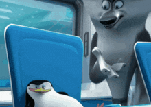 a penguin sits next to a shark on a blue chair