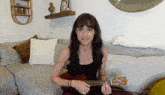 a woman sitting on a couch playing a guitar