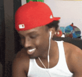 a man wearing a red hat and ear buds smiles
