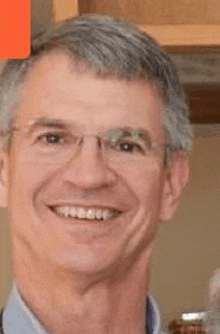 a close up of a man wearing glasses smiling .