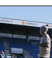 a woman running in a stadium with a sign that says komplett on it