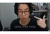 a man wearing headphones and glasses is pointing at something in a room .