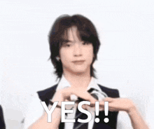 a man in a suit and tie is smiling and holding a camera with the words yes written above him