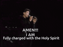a man singing into a microphone with the words amen !!! i am fully charged with the holy spirit
