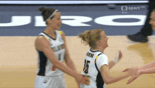 two female basketball players on a court with the word sport on the bottom