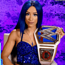 a woman with blue hair is holding a wrestling championship belt that says ' bliss ' on it