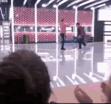 a group of people are dancing on a stage in a room with a red wall .