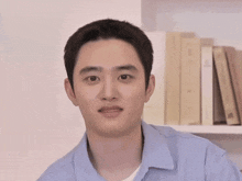 a man in a blue shirt is looking at the camera