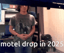 a man in a motel drop in 2025 shirt stands in a room