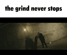 a poster that says the grind never stops with a man standing in a dark room
