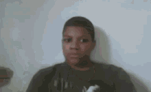 a young boy is making a funny face in front of a camera .
