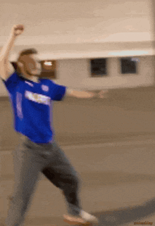 a blurry picture of a man in a blue shirt with the number 1
