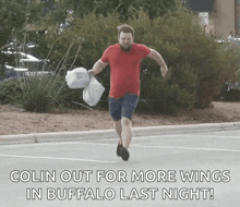 a man in a red shirt is running in a parking lot with the words colin out for more wings in buffalo last night