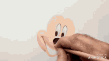 a person is drawing a picture of mickey mouse with a pencil .