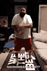 a man in a white shirt and red shorts is dancing on a table .