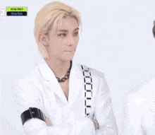a man with blonde hair is sitting next to another man with black hair .