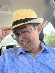 a man wearing a hat and glasses is smiling