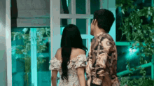 a man and a woman are standing next to each other in a room .
