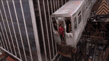 a woman in a red superhero costume is standing on the side of a subway train with the number 1103 on it