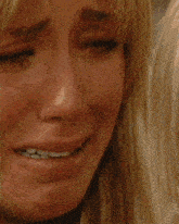 a woman in an orange tank top kisses another woman