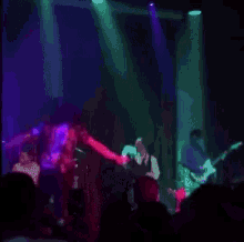 a group of people are playing instruments on a stage in a dark room .