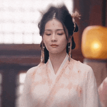 a woman with her eyes closed wearing a kimono and earrings