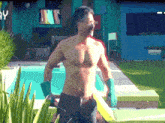 a shirtless man is standing in front of a swimming pool with a tv behind him that says yy