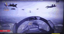 a tv screen shows a group of fighter jets flying in the sky