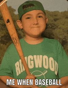 a young boy wearing a ringwood baseball shirt holds a baseball bat