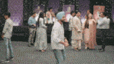 a man in a turban is dancing in a room full of people