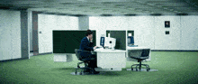a man sits at a desk in front of a computer and talks on the phone