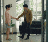 two men shaking hands in a room with a couch