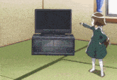 a girl is standing in front of a tv and pointing at it