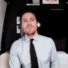 a man wearing a light blue shirt and black tie