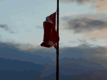 a canadian flag is flying in the wind