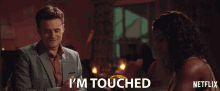 a man in a suit says i 'm touched next to a woman