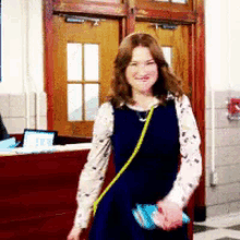 a woman in a black dress is standing in a hallway