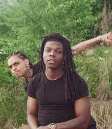 a man with dreadlocks has a watch on his wrist that says ' g-shock '