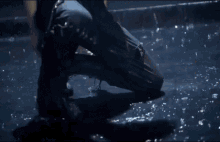 a man is kneeling down in the rain with his hands in the water .