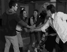 a group of people are putting their hands together