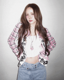 a woman wearing a plaid shirt and a necklace with a heart on it