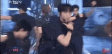 a group of men are dancing on a stage in a room .