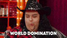 a man wearing a cowboy hat and plaid shirt says world domination