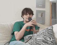 a young man is sitting on a couch holding a microphone in front of a youtube wall